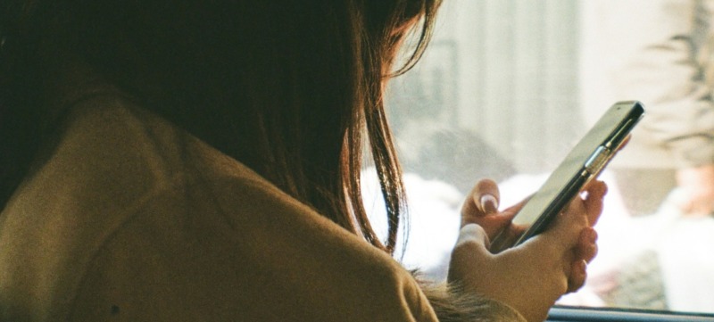 vrouw zit in haar telefoon gedoken en praat minder
