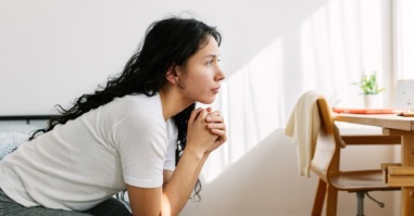 vrouw kijkt gespannen voor zich uit en denkt na over familiedynamieken