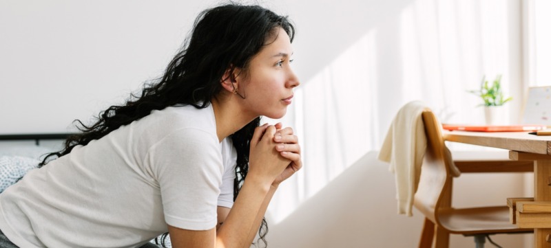 vrouw kijkt gespannen voor zich uit en denkt na over familiedynamieken