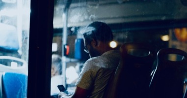 man zit alleen in de bus