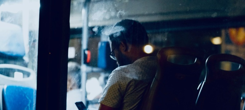 man zit alleen in de bus