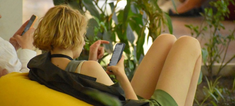 vrouw zit op social media maar wil stoppen met doomscrollen