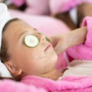 kind gebruikt skincare en ligt met maskertje op de bank