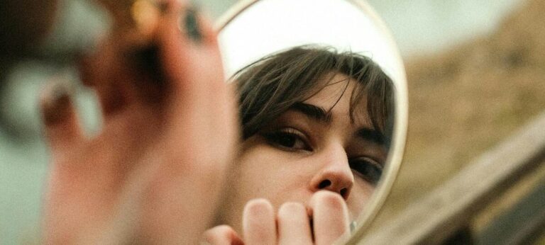 een vrouw die in de spiegel kijkt om lippenstift