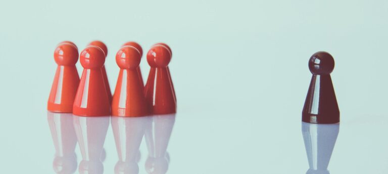 een groep met rode poppetjes staan links en één zwart poppetje staat rechts