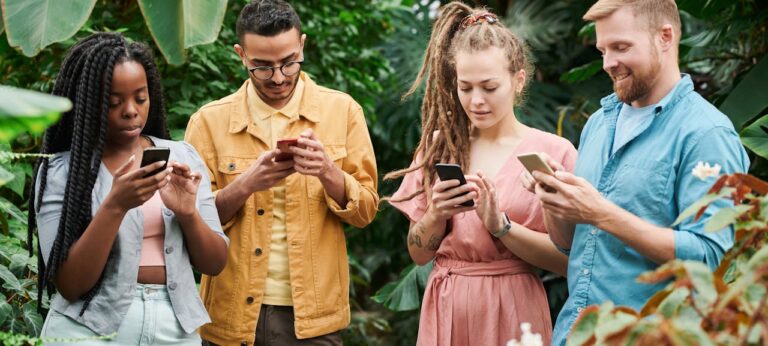 Vier personen op mobiel als beeld bij artikel social media