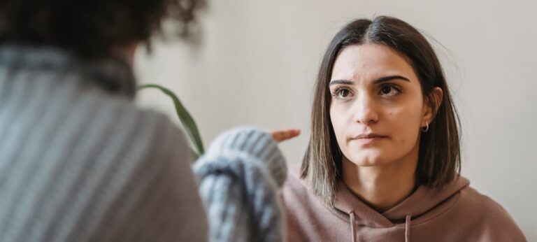 vrouw die afkeurend met vinger naar andere vrouw wijst