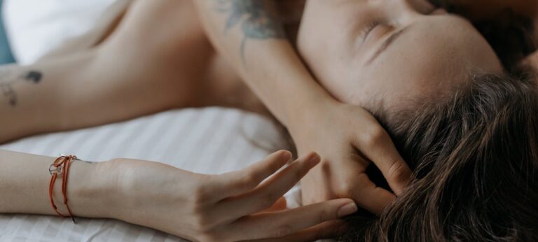 Vrouw die op bed ligt als beeld bij artikel over genieten van seks bij vrouwen